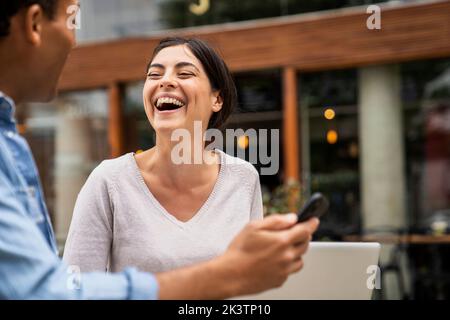 Ein Seitenfoto von verschiedenen Paaren, die sich gut amüsiert und mit ihren Online-Inhalten lacht Stockfoto