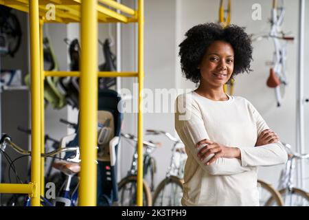 Mid-Shot-Porträt der weiblichen afroamerikanischen Fahrradladen-Besitzerin Stockfoto