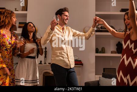 Fröhliche Jugendliche vielfältige Gesellschaft von Freunden entspannen und tanzen während Home Party Stockfoto