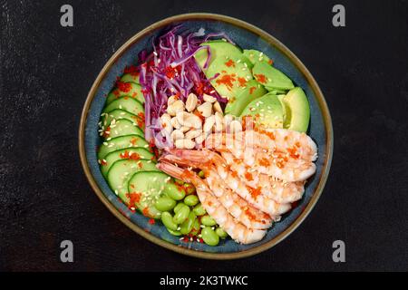 Draufsicht auf Sack-Salat mit roten Garnelen und grünem Gemüse in den Schüsseln auf grauem Hintergrund. Speicherplatz kopieren. Stockfoto