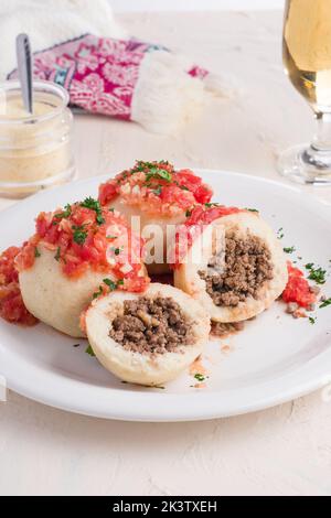 Hoher Winkel der Platte mit bollos Pelones köstliche Hackfleischbällchen in Arapa-Teig bedeckt und mit herzhafter Tomatensauce serviert Stockfoto