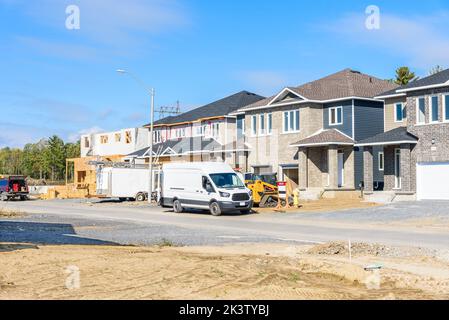 Doppelhaushälften im Bau in einer Wohnsiedlung an einem klaren Herbsttag Stockfoto