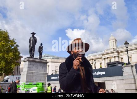 London, Großbritannien. 28. September 2022. Der Künstler Samson Kambalu genießt eine Zigarre neben seiner Skulptur 'Antelope', die als neuestes Kunstwerk für den vierten Sockel auf dem Trafalgar Square enthüllt wurde. Das Kunstwerk zeigt Statuen des panafrikanischen Predigers und Baptistenpredigers John Chilembwe und des europäischen Missionars John Chorley. Kredit: Vuk Valcic/Alamy Live Nachrichten Stockfoto