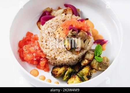 Mit braunem Reis, Lachs und gegrilltem Gemüse poken Stockfoto