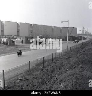 1950er Jahre, historisch, ein Blick auf die East Road bei der Steel Company of Wales Riesen Manufacturing Factory of Abbey Works in Port Talbot, Wales, Großbritannien, mit großen Gebäuden und einer SCOW-Bushaltestelle. Stockfoto