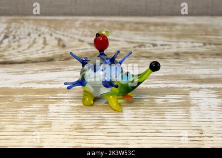 Miniatur-Igel-Figur aus Glas auf rauer Oberfläche aus Holz aus nächster Nähe Stockfoto