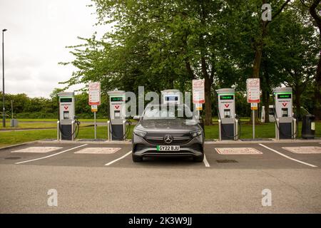 Eine schwarze Mercedes-Auto-Ladestation für Elektrofahrzeuge mit einer eingesteckten Instavolt-Ladestation Stockfoto