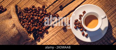 Schaumige Kaffeecrema in kleiner Tasse mit Untertasse auf Holz Stockfoto