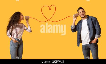 Frau Sendet Liebesnachricht An Freund Über Telefon Mit Herzförmiger Schnur Stockfoto