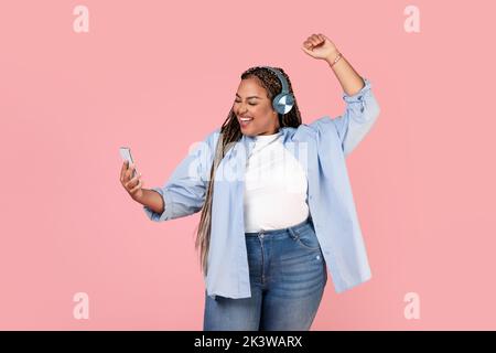 Schwarze Frauen Tanzen Musik Hören Tragen Kopfhörer Holding Smartphone, Studio Stockfoto