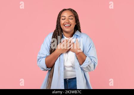 Dankbare Afroamerikanische Frau, Die Die Hände An Die Brust Drückt, Rosa Hintergrund Stockfoto