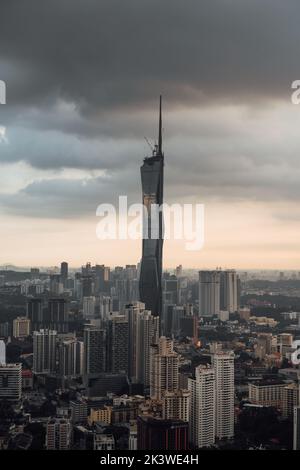 Eine vertikale Aufnahme der wunderschönen städtischen Skyline von Kuala Lumpur bei Sonnenuntergang mit dem Warisan Merdeka Tower Stockfoto