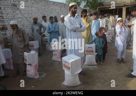 Peshawar, Pakistan. 22. September 2022. Die von Überschwemmungen betroffenen Menschen erhalten am 22. September 2022 von der Al Khidmat Foundation im Bezirk Nowshera, Dorf Garhi Momin, Provinz Khyber Pakhtunkhwa in Peshawar, Pakistan, Hilfsgelder. (Foto: Hussain Ali/Pacific Press/Sipa USA) Quelle: SIPA USA/Alamy Live News Stockfoto