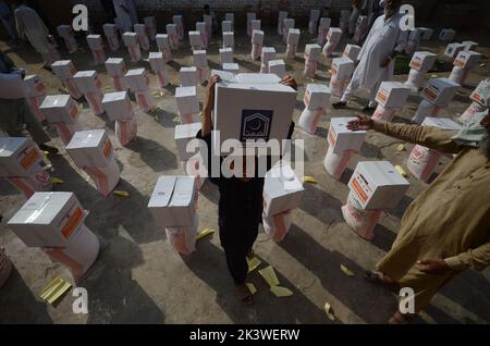 Peshawar, Pakistan. 22. September 2022. Die von Überschwemmungen betroffenen Menschen erhalten am 22. September 2022 von der Al Khidmat Foundation im Bezirk Nowshera, Garhi Momin Village Khyber Pakhtunkhwa, Provinz in Peshawar, Pakistan, Hilfsgelder. (Foto: Hussain Ali/Pacific Press/Sipa USA) Quelle: SIPA USA/Alamy Live News Stockfoto