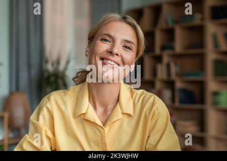 Porträt einer positiven Psychologin mittleren Alters, die während einer Therapiesitzung im Büro mit der Kamera spricht und lächelt Stockfoto