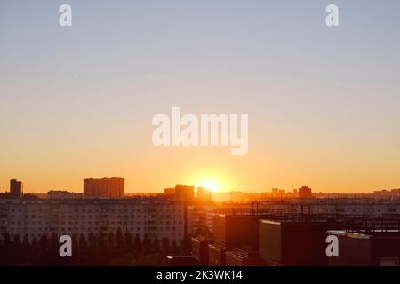 Die Sonne geht über der Skyline auf und erhellt die Häuser und Straßen der schlafenden Stadt Stockfoto