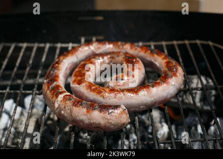 Frische Wurst Kochen auf dem Grill, in der frischen Luft des Hauses. Stockfoto