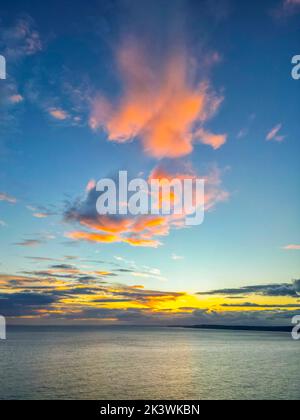 West Bay, Dorset, Großbritannien. 28.. September 2022. Wetter in Großbritannien. Die Wolken über dem Meer leuchten an der West Bay in Dorset bei Sonnenuntergang an einem duschenden Abend orange. Bildnachweis: Graham Hunt/Alamy Live News Stockfoto