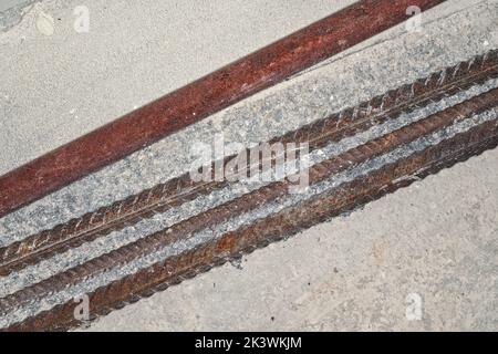 Eisenrost Konstruktion Rebars auf Betonboden auf der Baustelle Nahaufnahme Detail von oben Stockfoto