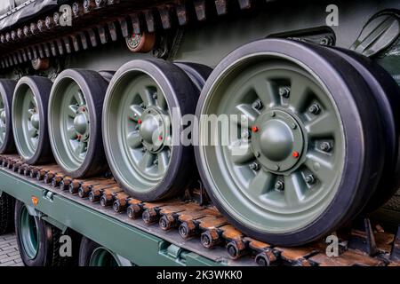 Gepanzertes Fahrzeug auf LKW geladen, Details zu den Rädern auf durchgehenden Laufflächen Stockfoto