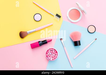 Make-up-Produkte und dekorative Kosmetika auf farbigem Hintergrund flach legen. Mode- und Beauty-Blogging-Konzept Stockfoto