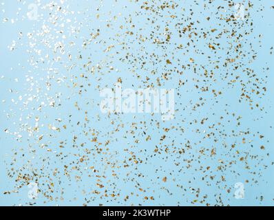 Goldenes Fliegen funkelt auf blauem Art und Weiseurlaub Hintergrund. Festlicher Hintergrund. Textur aus goldenem Glitzer auf Blau Stockfoto