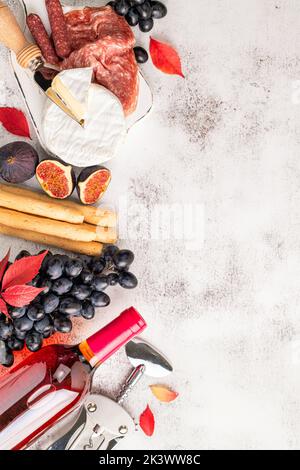 Vorspeisen auf dem Tisch mit italienischen Antipasto-Snacks und Wein. Trauben, Feigen, Käse Camembert, Brotstock, Fleisch Snaks. Antipasti, Gourmet, romantische Konce Stockfoto