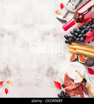 Vorspeisen auf dem Tisch mit italienischen Antipasto-Snacks und Wein. Trauben, Feigen, Käse Camembert, Brotstock, Fleisch Snaks. Antipasti, Gourmet, romantische Konce Stockfoto
