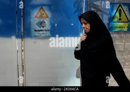 Teheran, Teheran, Iran. 28. September 2022. Eine verschleierte Frau geht in einer Straße in Teheran, Iran, 28. September 2022. Nach dem Tod von Masha Amini, einem 22-jährigen Mädchen, das am 13. September von der Polizeieinheit, die für die Durchsetzung der strengen iranischen Kleiderordnung für Frauen verantwortlich ist, festgenommen wurde, ist der Iran mit zahlreichen regierungsfeindlichen Protesten konfrontiert. Amini wurde am 16. September für tot erklärt, nachdem sie 3 Tage im Koma verbracht hatte. Während ihrer Beerdigung am 17. September brachen in Saqez, der Heimatstadt von Amini, erste Proteste aus. (Bild: © Rouzbeh Fouladi via ZUMA Press Wire) Stockfoto