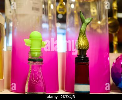 Nahaufnahme von lustigen Weinkorkstoppern in Weinflaschenoberteilen vor den Fushia Vasen in Party-Setting Stockfoto