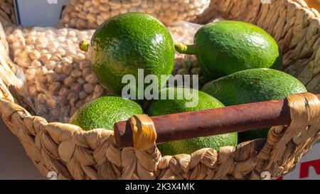 Avocados und Kichererbsen in einem Weidenkorb, Gemüse und Hülsenfrüchte Stockfoto
