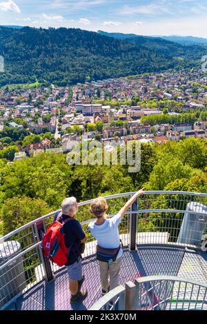 Mann und Frau genießen die Aussicht von der Spitze des Aussichtsturms Schlossberg in Schlossberg, Freiburg im Breisgau, Deutschland Stockfoto