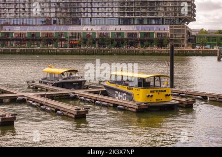 Rotterdam, Niederlande - 11. Juli 2022: 2 gelb-schwarze DHG-Wassertaxi-Boote dockten an Rijnhaven mit Nico Koomanskade an, auf dem Fenix Food Fact Stockfoto