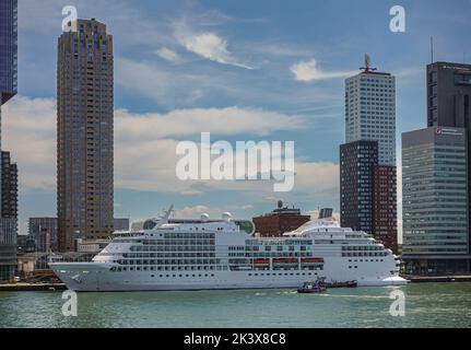 Rotterdam, Niederlande - 11. Juli 2022: White Seven Seas Navigator Schiff dockte am Terminal auf Kop van Zuid Dock unter blauer Wolkenlandschaft mit hoch Stockfoto