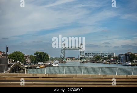 Rotterdam, Niederlande - 11. Juli 2022: Koningshavenbrug, Metallbrücke, AKA De Hef, in Koningshaven, Hafen, unter blauer Wolkenlandschaft. Viele Boote auf Docks Stockfoto