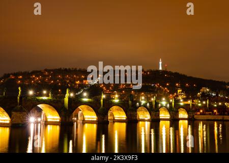 Karlsbrücke in der Altstadt, Prag, Tschechische Republik bei Nacht. Leuchtet. Petrin Hügel im Hintergrund. Stockfoto