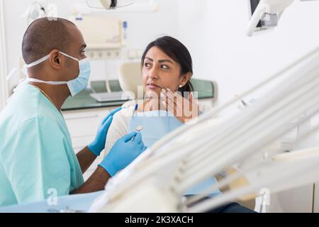 Professioneller Arzt Mann im Gespräch mit dem Patienten auf dem Stuhl Stockfoto