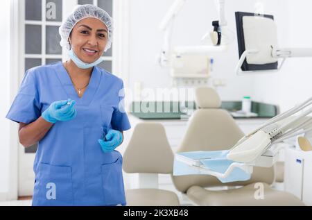 Lächelnde professionelle Zahnärztin Frau posiert in der Zahnklinik Stockfoto