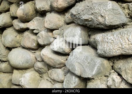 Steinwand aus großen abgerundeten Hügeln in verschiedenen Farben. Textur oder Hintergrund. Stockfoto