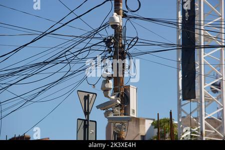 Bukarest, Rumänien - 28. September 2022: Viele Überwachungskameras, Internet- und Kommunikationskabel hängen an Säulen in Bukarest. Stockfoto