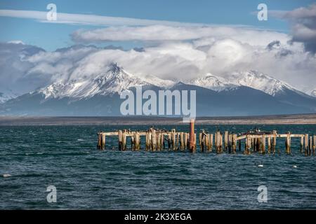 Braun & Blanchard Pier in Puerto Natales mit Weißbrustkormoranen und Bergkette im Hintergrund Stockfoto