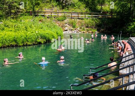 Touristen, die die heißen Quellen am Liard River, den Liard River Provincial Park, British Columbia und Kanada genießen Stockfoto