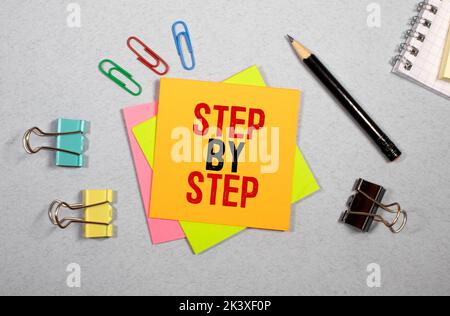Schritt für Schritt Wort auf Holzblock geschrieben. Schritt für Schritt Text auf Tabelle, Konzept. Stockfoto