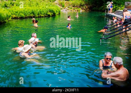 Touristen, die die heißen Quellen am Liard River, den Liard River Provincial Park, British Columbia und Kanada genießen Stockfoto