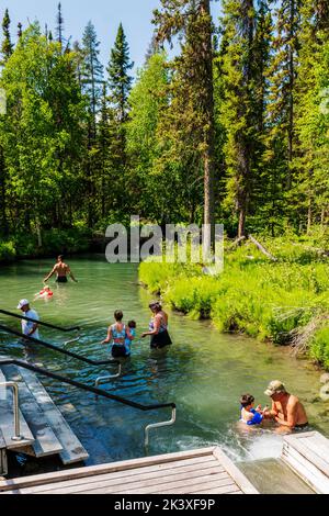 Touristen, die die heißen Quellen am Liard River, den Liard River Provincial Park, British Columbia und Kanada genießen Stockfoto