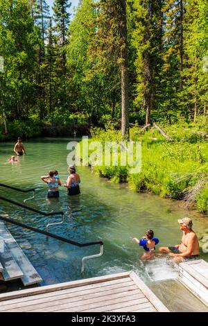 Touristen, die die heißen Quellen am Liard River, den Liard River Provincial Park, British Columbia und Kanada genießen Stockfoto