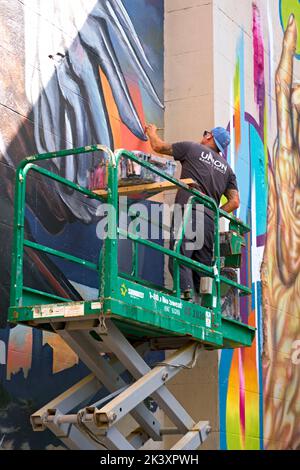 Der Künstler Ed Trask kreiert ein neues Wandgemälde während des RVA Street Art Festivals 2022 im Kraftwerk entlang des Canal Walk von Richmond VA. Stockfoto