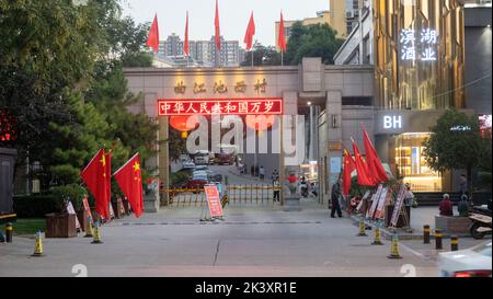 XI'AN, CHINA - 28. SEPTEMBER 2022 - Nationalflaggen fliegen auf einer Straße in der alten Stadt Xi'an, um den Nationalfeiertag in Xi'an, Provinz Shaanxi, zu begrüßen. Stockfoto