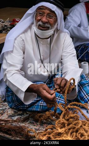 Afro-Araber aus Abu Dhabi beim Folklife Festival in dishdaha, Ghutra und Agal, das Kokosfaserseil für die Herstellung traditioneller Fischernetze herstellt. Stockfoto