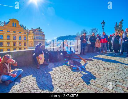 PRAG, TSCHECHISCHE REPUBLIK - 12. MÄRZ 2022: Straßenmusiker spielen auf der Karlsbrücke am 12. März in Prag, Tschechische Republik, der überfüllteste Platz der Stadt Stockfoto